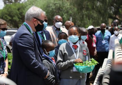 Tender Care Junior Academy pupil briefing Luke Williams, Australian High Commissioner to Kenya as Kenneth Monjero looks on and other guests to see some of the crops to be used on the launched Agritech.
