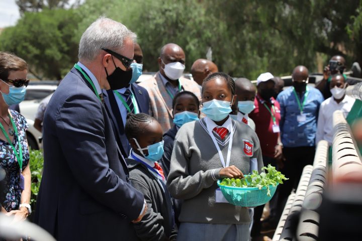 Tender Care Junior Academy pupil briefing Luke Williams, Australian High Commissioner to Kenya as Kenneth Monjero looks on and other guests to see some of the crops to be used on the launched Agritech.